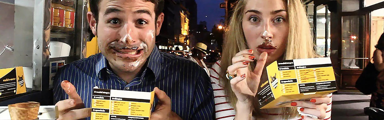 Happy couple enjoying their waffles with chocolate all over their face and a guilty look