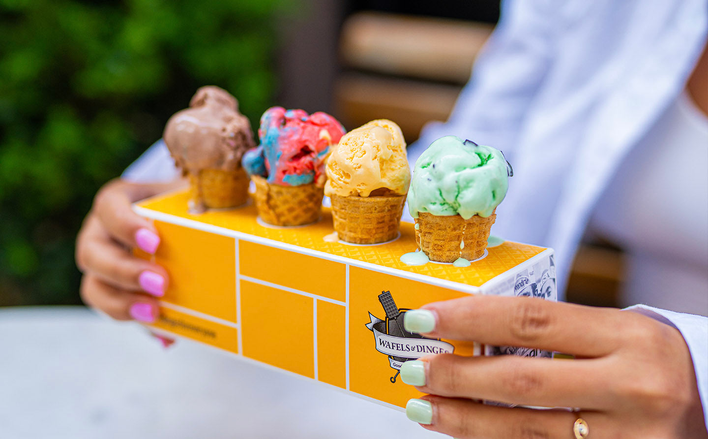 Customer holding a colorful ice cream flight