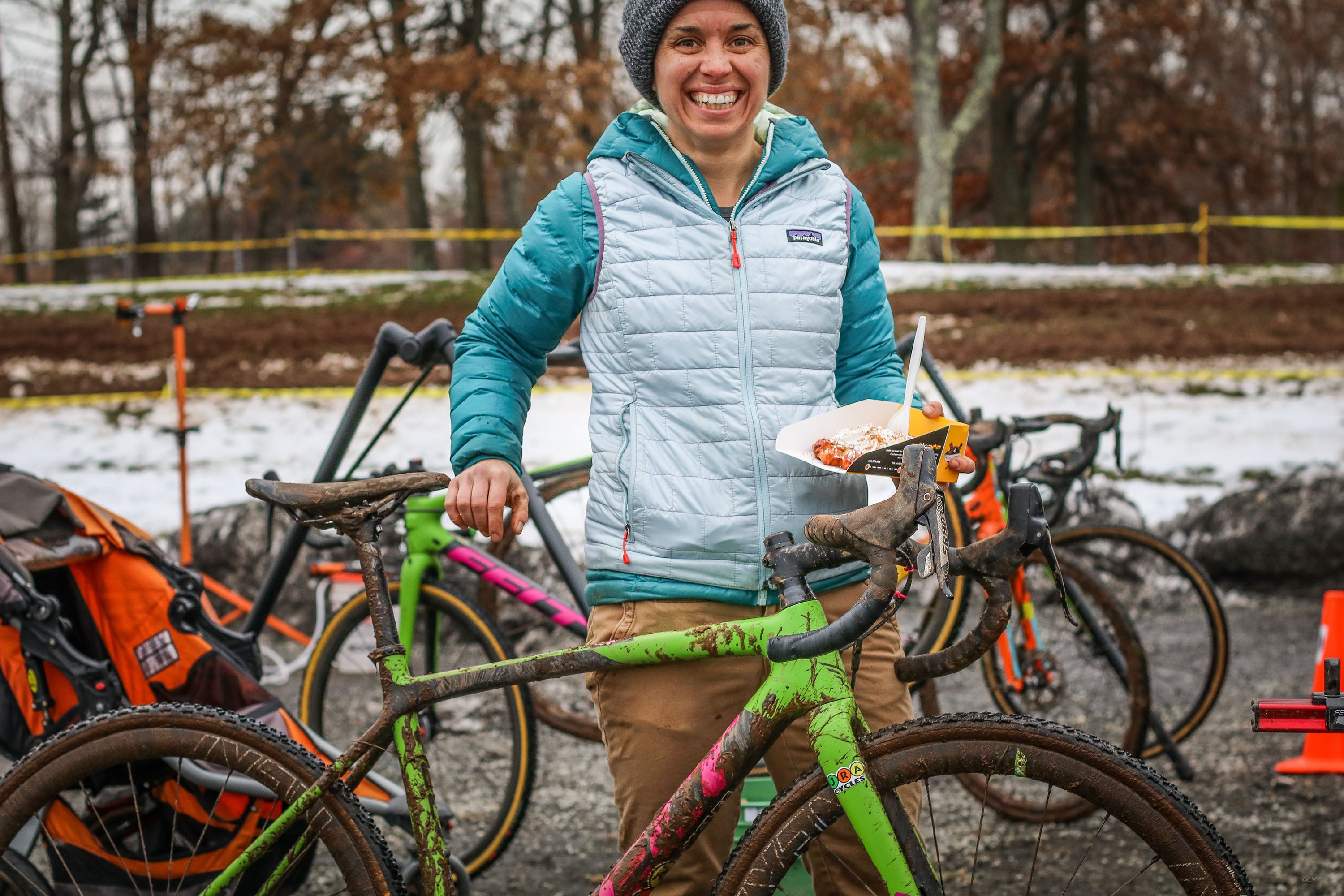 A bicycle athlete enjoying a waffle after a muddy winter race
