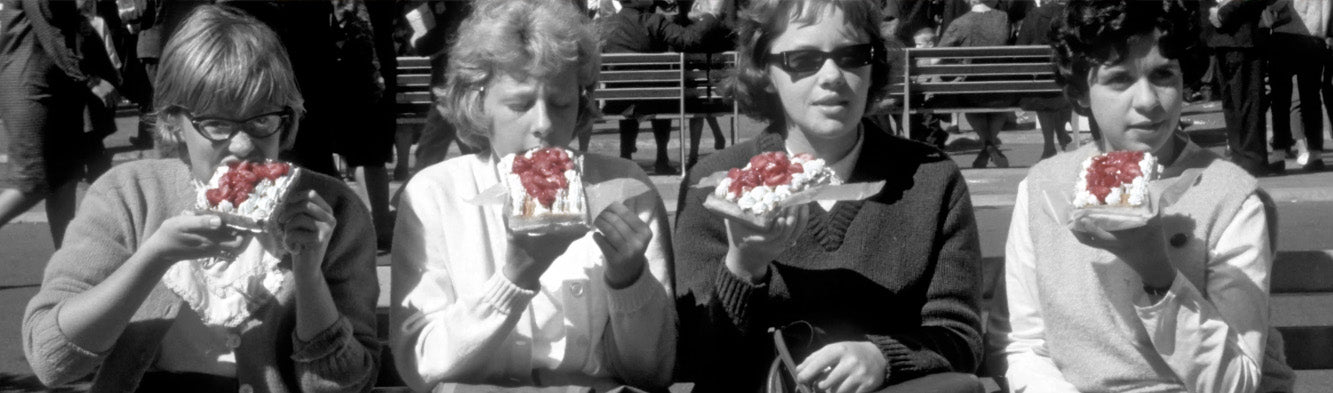Vintage picture of the World’s Fair in New York, four ladies sitting on a bench while enjoying Belgian waffles.