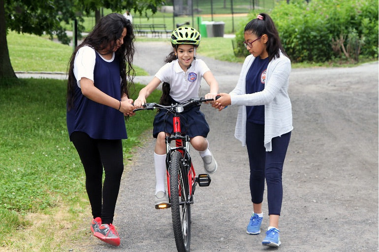 A little girl learning how to ride a bicycle