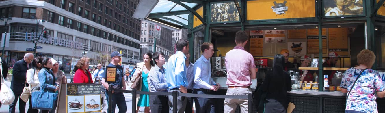 Queue of customers ordering waffles at Wafels and Dinges kiosk in Herald Square, New York.