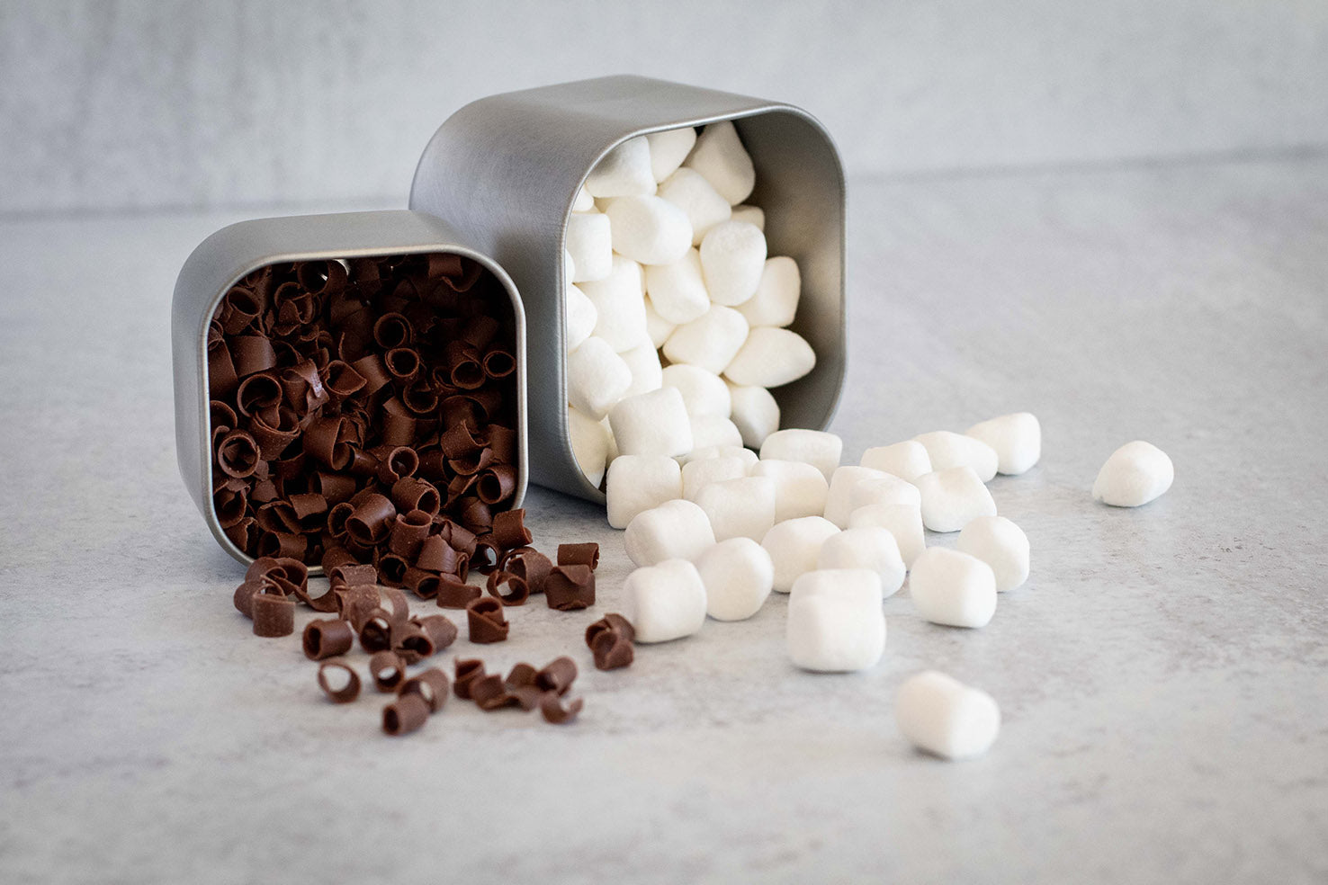 A tin with marshmallows and a tin with chocolate curls