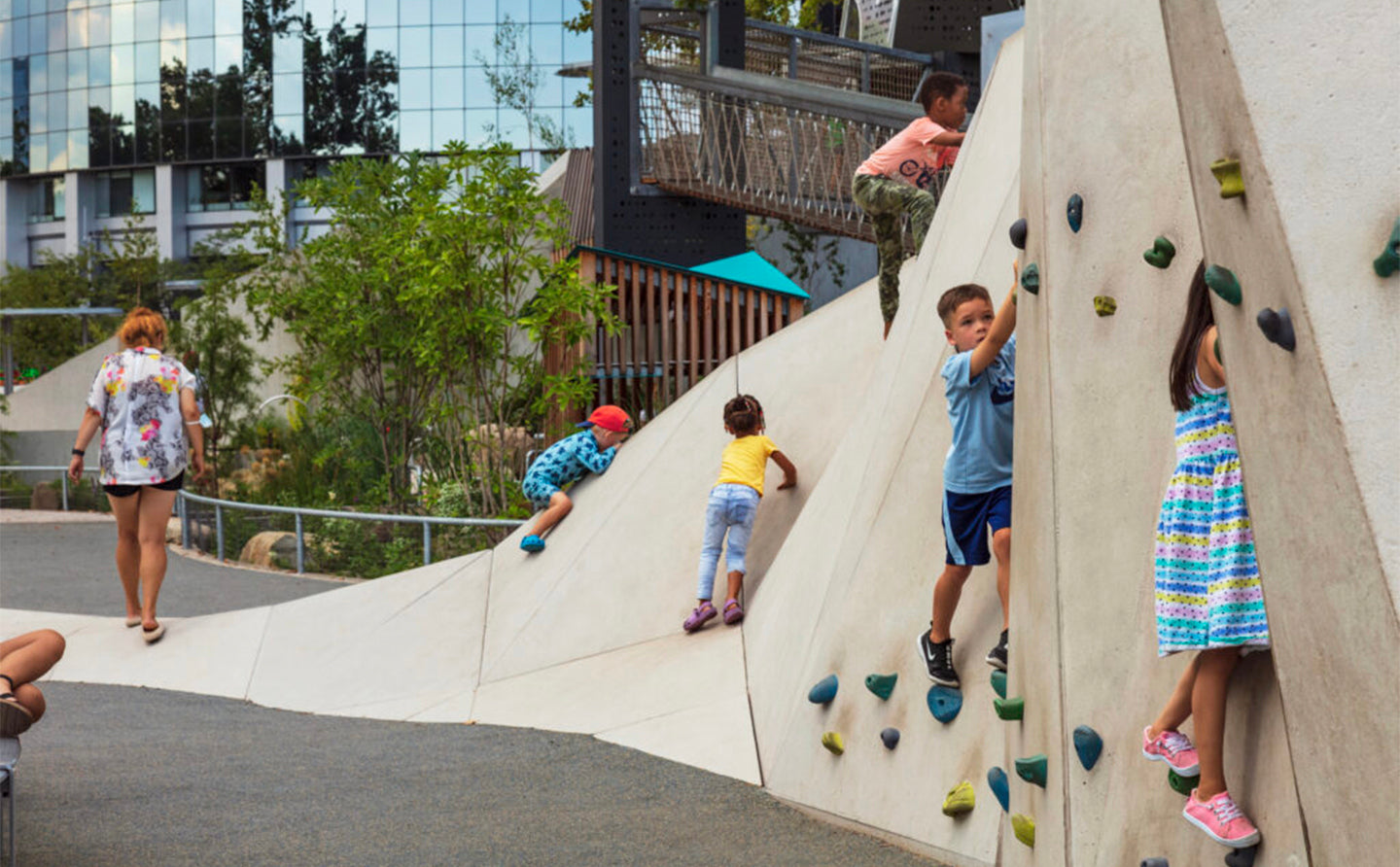 Kids playing in an exterior  playground with climbing wall