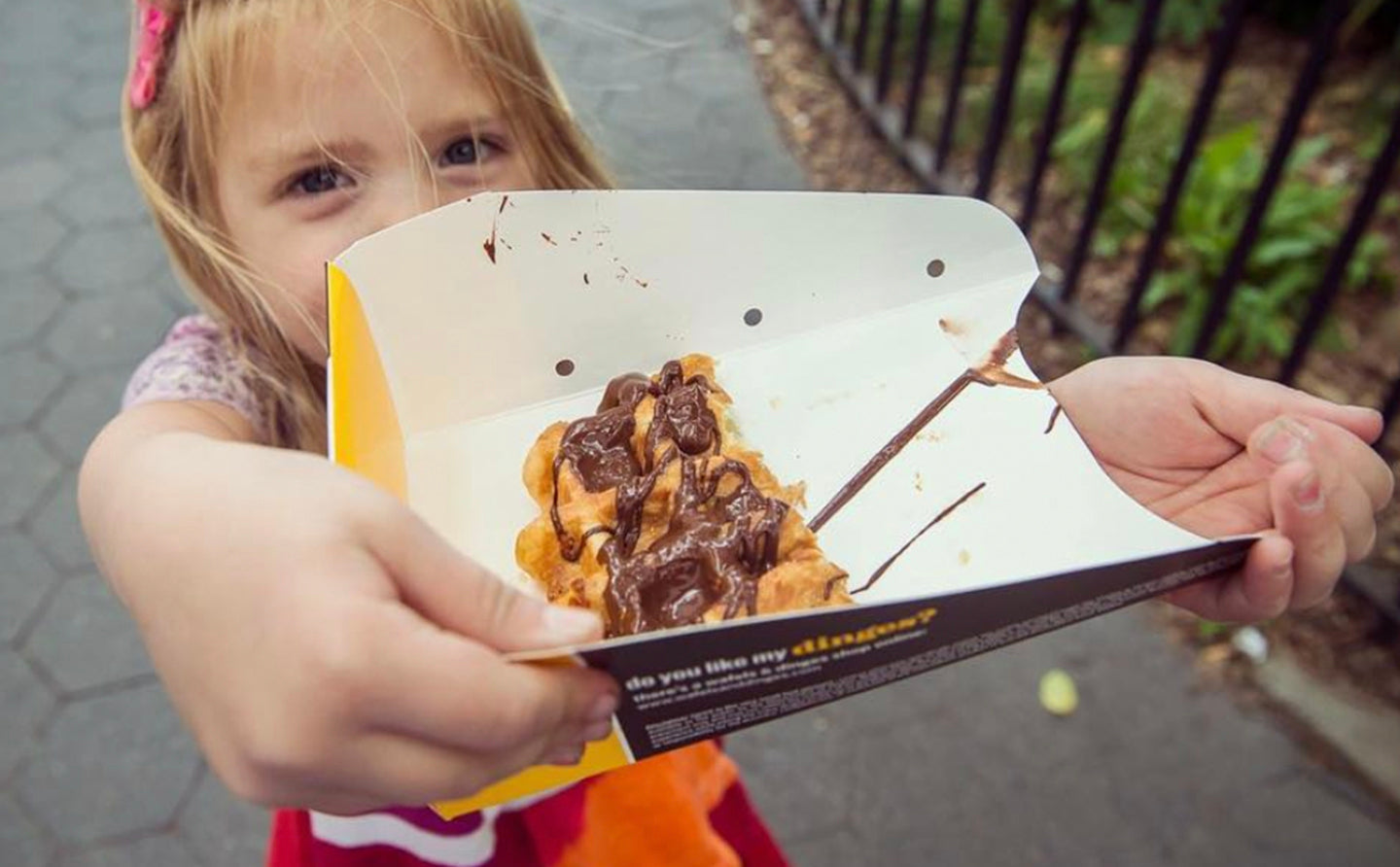 Little girl showing proudly her chocolate waffle