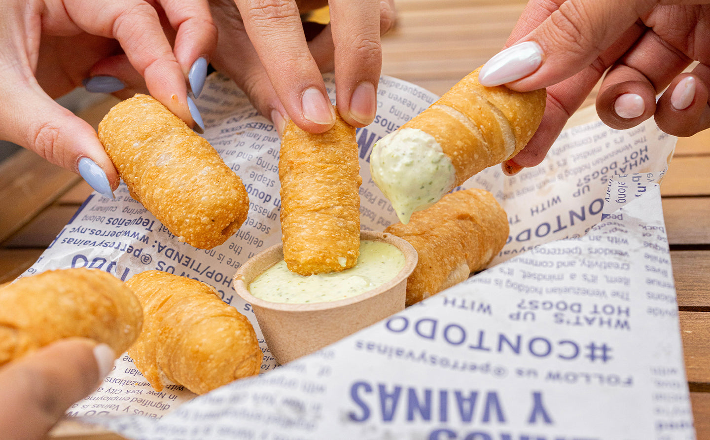 A group of people dipping a prawn in  sauce