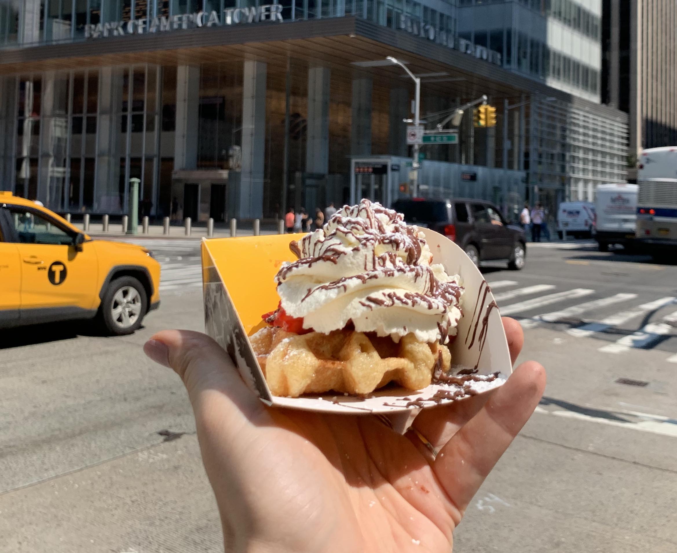 A man click photo of wafels while picking in his hand in streets